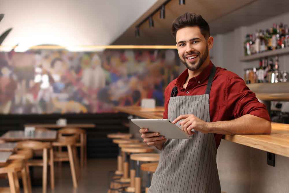 Store owner working on Branding for his businesses - standing inside his restaurant